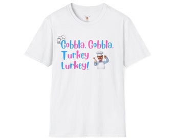 Puede incluir: Camiseta blanca con un chef de dibujos animados que lleva un gorro de cocinero azul y blanco y un delantal. El texto "Gobbla, Gobbla, Turkey Lurkey!" está impreso en rosa y azul.
