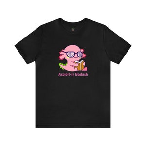 May include: Black t-shirt with a pink axolotl wearing glasses and reading a book. The text "Axolotl-ly Bookish" is printed below the axolotl.