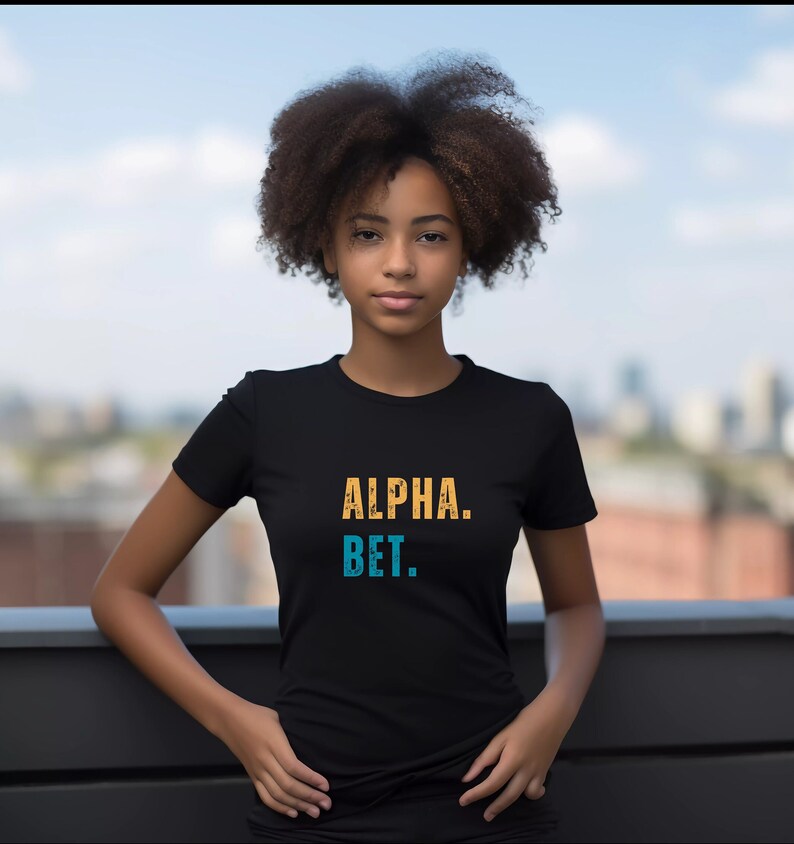 May include: A black t-shirt with the text "ALPHA. BET." in yellow and blue lettering.