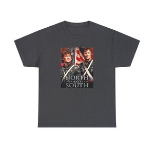 May include: A dark heather grey t-shirt with a graphic print of two men in military uniforms standing in front of an American flag. The text "NORTH AND SOUTH" is printed below the image.