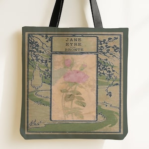 May include: A tote bag featuring a book cover design for Jane Eyre by Bronte. The graphic displays a central rectangular panel with a pink rose illustration, surrounded by a green landscape with trees and a winding path. It has black straps.