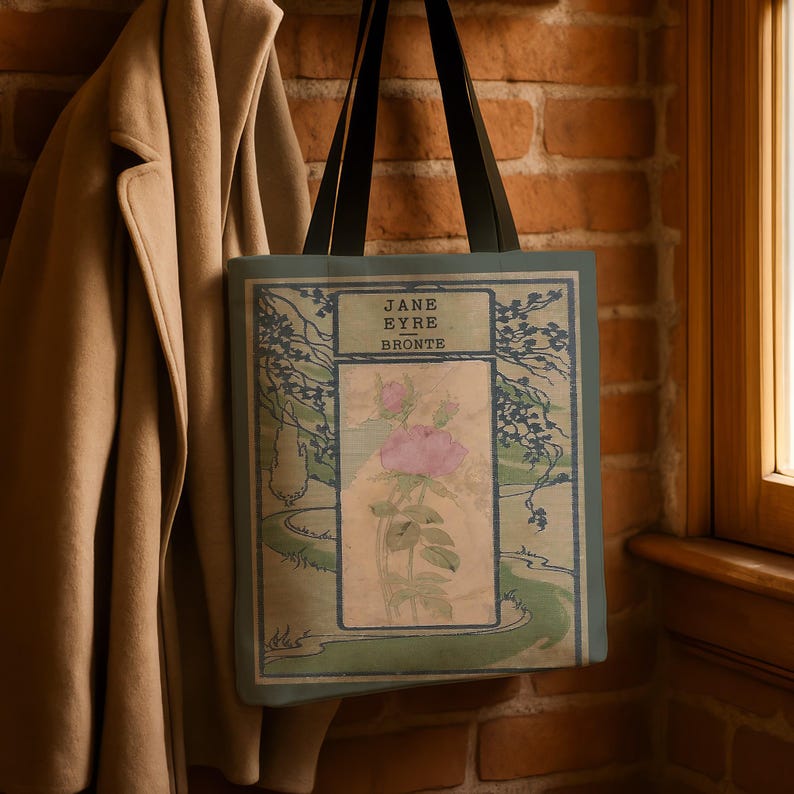 May include: A tote bag with black handles featuring a book cover design for Jane Eyre by Bronte. The graphic includes a central pink rose illustration, green landscape elements, and dark blue tree branches on a light green background.