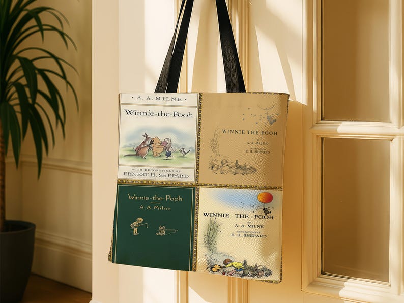 Pode incluir: Bolsa tote com quatro pain&eacute;is com ilustra&ccedil;&otilde;es e texto do livro infantil cl&aacute;ssico "Winnie-the-Pooh" de A.A. Milne. A bolsa tem al&ccedil;as pretas e est&aacute; pendurada em frente a uma porta.
