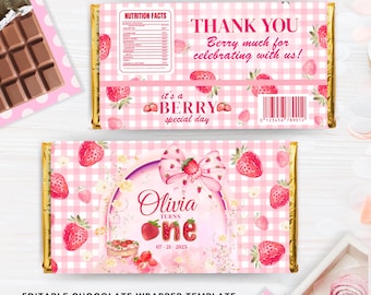 May include: A pink and gold chocolate wrapper template with a strawberry theme. The wrapper features text that says "Thank You" and "Olivia turns one". The wrapper is 5.29" x 6.25" in size.