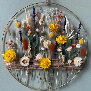 Floral gold hoop with dried flowers. Wreath like summer meadow, wall decor for boho style house