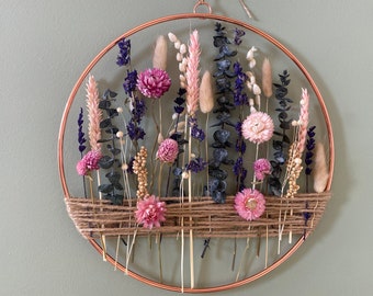 Elegant wreath on rose gold hoop adorned with eucalyptus, pink, and blue dried flowers. A stunning decoration perfect for gift.