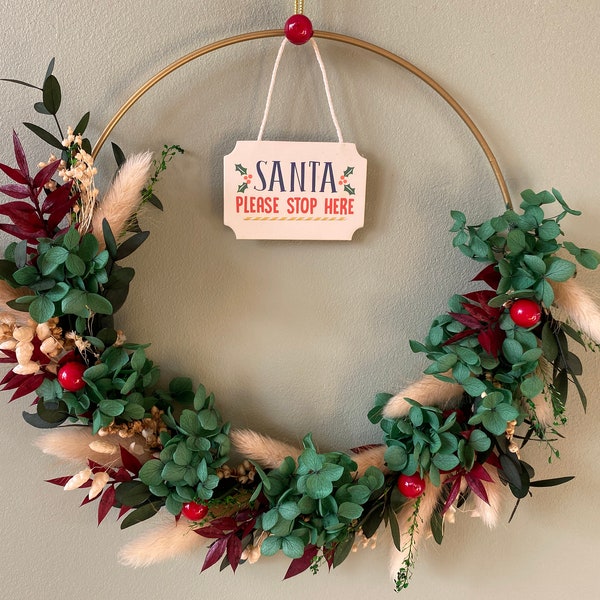 Magical Christmas Wreath on Golden Hoop with Dried Flowers and Santa Claus Ornament. Holiday Decoration 2023