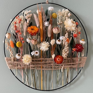 Warm home decoration to hang. Golden hoop with dried flowers and green eucalyptus leaves.