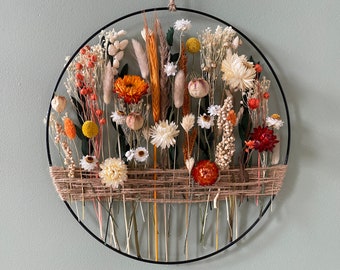 Warm home decoration to hang. Golden hoop with dried flowers and green eucalyptus leaves.