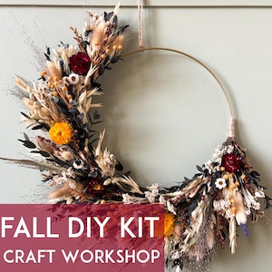 Op de afbeelding: Een herfst-DIY-kit met een halve cirkelkrans. De krans is versierd met gedroogde bloemen in oranje, crème, bordeauxrood en zwart. De tekst "FALL DIY KIT" en "FALL CRAFT WORKSHOP" staat op een bordeauxrode banner.
