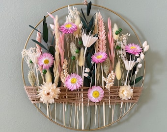 Spring wreath with pink daises for sunny home. Easter decoration with dried flowers for present.