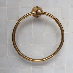 Toallero de aro de latón sin lacar con acabado liso, elegante accesorio de baño para montar en la pared.