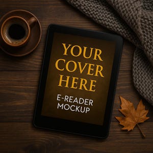 Puede incluir: Una maqueta de lector electrónico negro con el texto "YOUR COVER HERE" y "E-READER MOCKUP" en letras doradas. Una taza de café en un platillo, una hoja marrón y una bufanda de punto están sobre una superficie de madera.
