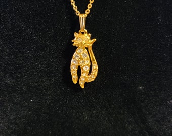 May include: A gold chain necklace with a rhinestone-encrusted cat pendant.