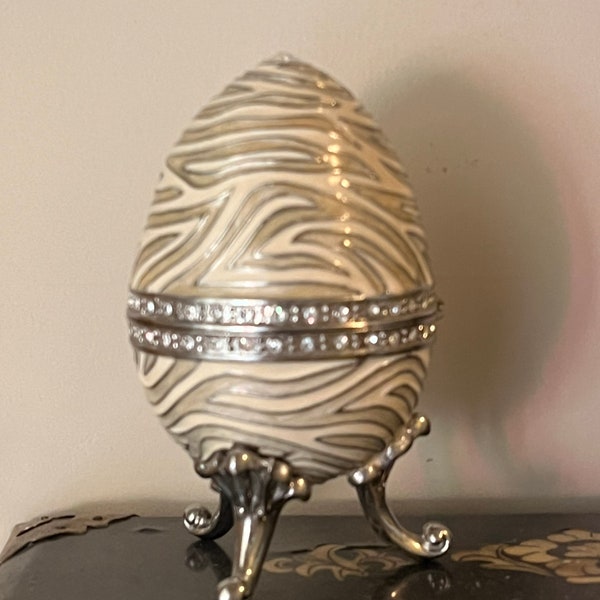 animal print musical Faberge style egg. It is beige and grey unique tiger stripe.Swarovski crystals plays you light up my life 4”gift!
