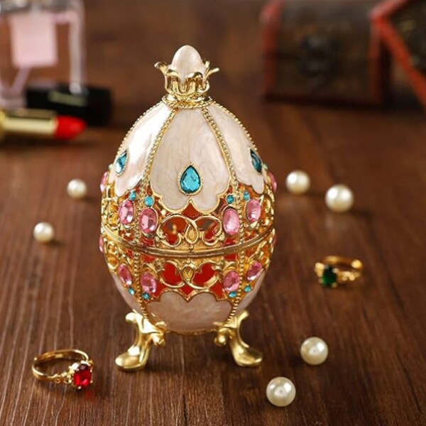 Faberge style cut out egg with blue Austrian crystals. It opens to hold jewelry or trinkets. This is a very unusual egg. Collector or gift!