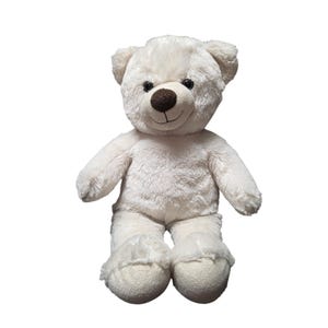 May include: A plush teddy bear with soft, off-white fur, featuring a dark brown stitched nose, a simple embroidered mouth, and two round black eyes. The bear is in a seated position with its arms resting at its sides and rounded feet.