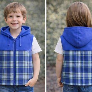 May include: A blue hooded vest with a blue and green plaid pattern. The vest has a full zip and is worn over a white t-shirt. The child is wearing blue jeans.