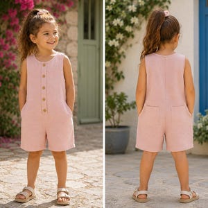 May include: A sleeveless light pink romper featuring a round neckline, a front button placket with five visible buttons, and two patch pockets on the back. The garment has a relaxed fit with short legs and is made of a textured fabric.