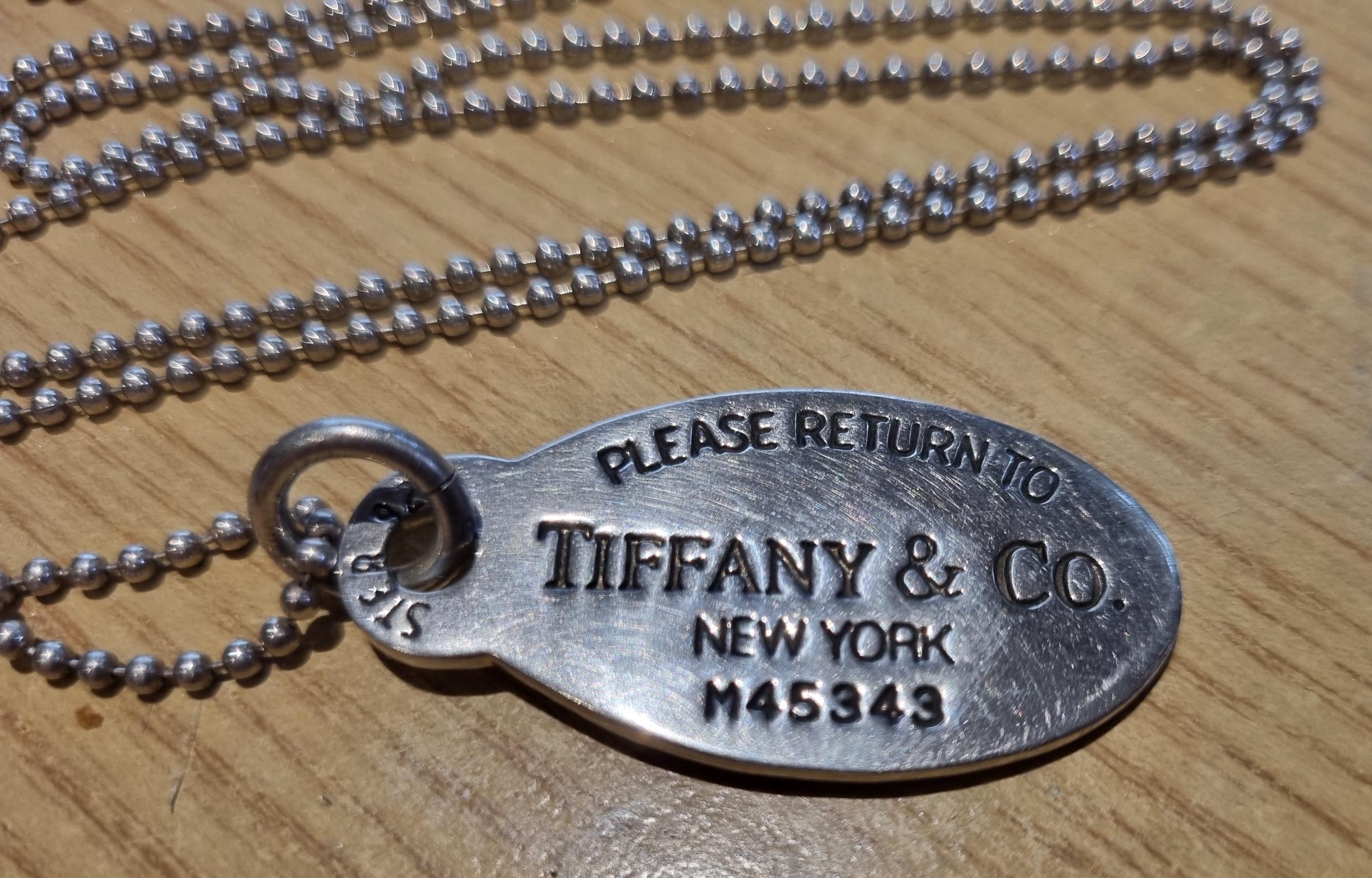 Please return to Tiffany New York silver pendant and chain.