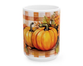May include: White ceramic mug featuring a fall-themed design. The mug showcases two orange pumpkins with green stems, surrounded by autumn leaves and flowers. The background has a brown and white checkered pattern.