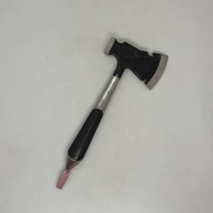 Könnte beinhalten: Ein Mini-Multitool mit schwarzem Axtkopf, silberner Klinge und Hammer. Der Griff ist silber und schwarz, mit einem rosaroten Meißel am Ende. Dieser Artikel ist als kleine Axt gestaltet.