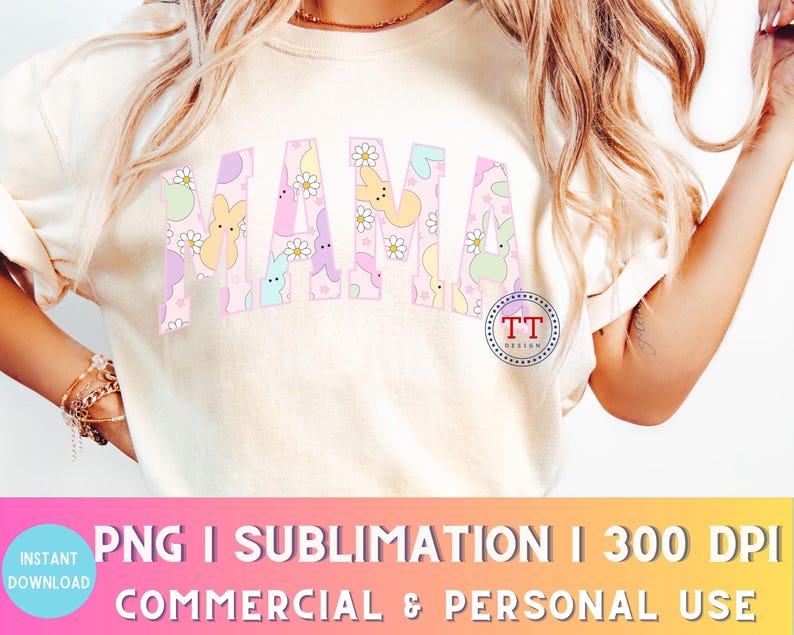Puede incluir: Una camiseta blanca con un dise&ntilde;o gr&aacute;fico rosa, azul y amarillo que dice "MAMA" en letras grandes. El gr&aacute;fico presenta conejos y flores de colores pastel.