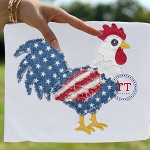 May include: White fabric with an embroidered rooster design. The rooster features a blue denim body with white stars, red and white striped accents, a red comb, and yellow feet. The design includes the text "TT DESIGN".