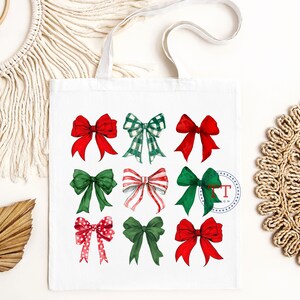 May include: A white tote bag with a design of nine red and green bows. The bows are in various patterns, including plaid, polka dots, and solid colors.