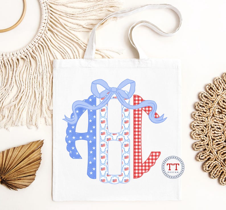 May include: White tote bag featuring a patriotic design. The design includes the letters "ABC" in red, white, and blue patterns, with a blue bow at the top. The letter "A" is blue with white stars, "B" has a pattern of American flags, and "C" is red gingham.
