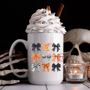 Pu&ograve; includere: Una tazza in ceramica bianca con un motivo a fiocco nero e arancione. La tazza &egrave; piena di panna montata e un bastoncino di cannella. La tazza &egrave; appoggiata su una superficie bianca con un teschio e un barattolo di pozione.