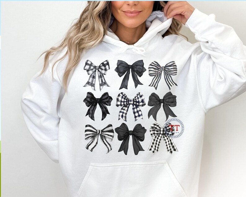 May include: White hoodie with a black and white bow design. The bows are arranged in a grid pattern and are all different sizes and shapes.