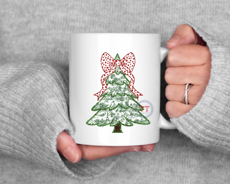 May include: White ceramic mug with a green Christmas tree design and a red and white polka dot bow. The tree is decorated with small, white dots.