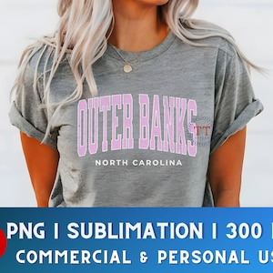 K&ouml;nnte beinhalten: Ein graues T-Shirt mit einer pinkfarbenen Grafik, auf der "Outer Banks" und "North Carolina" steht.