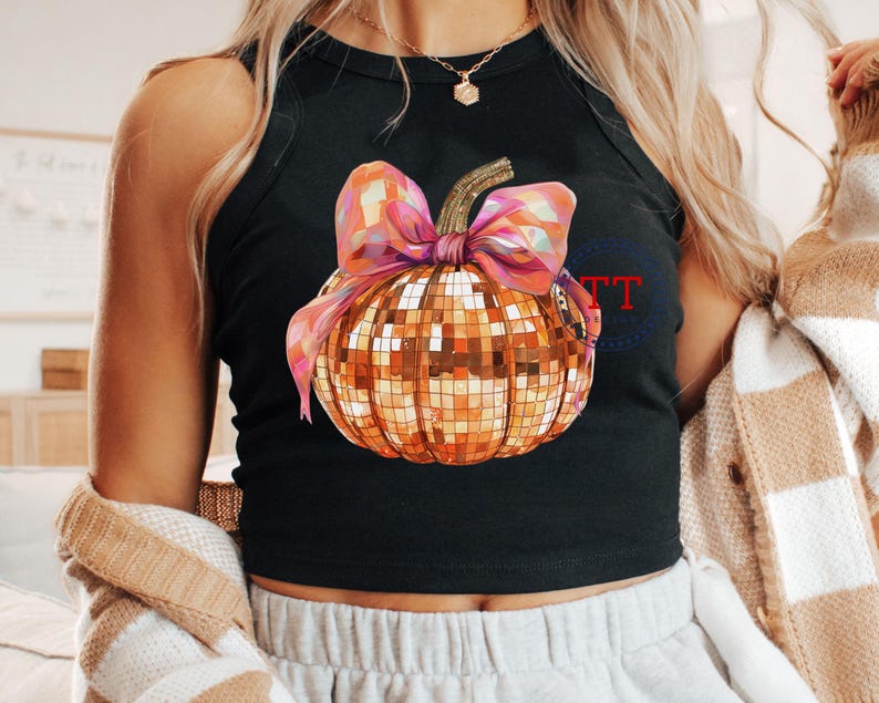 K&ouml;nnte beinhalten: Ein schwarzes Tanktop mit einem goldenen Glitzerk&uuml;rbis mit einer rosa Schleife. Der K&uuml;rbis hat ein Discokugel-Design.