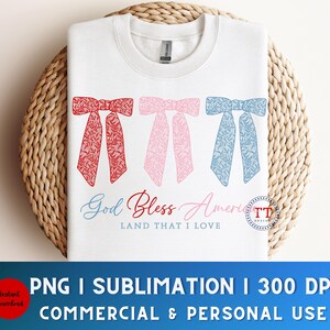 Puede incluir: Una sudadera blanca con un dise&ntilde;o de lazo rojo, blanco y azul y el texto "God Bless America Land That I Love".