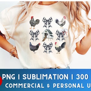 May include: A white t-shirt with a design of a white farmhouse with a red roof, black and white chickens, and black and white gingham bows. The design is centered on the shirt.