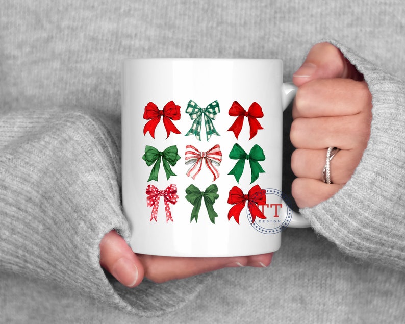 May include: White ceramic mug with a design of nine red and green bows. The bows are arranged in three rows of three. The mug has a blue and white stamp with the text "TT Design".