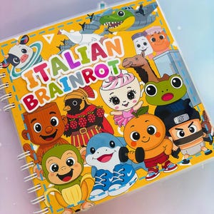Może przedstawiać: Spiralny notatnik z żółtą okładką z napisem "ITALIAN BRAINROT" i postaciami z kreskówek. Okładka ma przezroczystą plastikową nakładkę. Postacie obejmują delfina, małpę, pomarańczę i inne fantazyjne wzory.