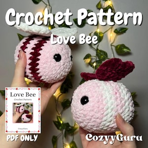 May include: A crochet pattern for a pink and red love bee. The pattern is available as a PDF download. The image shows two crocheted love bees, one with wings and one without. The text "Love Bee Crochet Pattern" and "CozyGuru" are visible in the image.