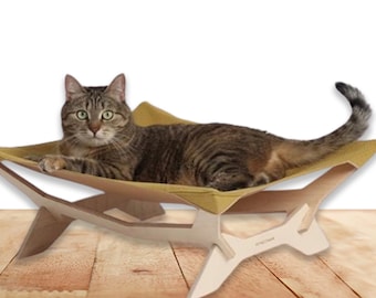 May include: A cat resting in a beige hammock bed made of wood and fabric. The bed has a unique geometric design and is supported by four legs. The cat is lying on its side with its head resting on the fabric.