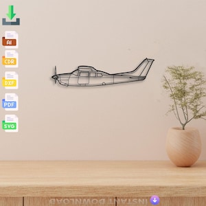 May include: Black metal airplane wall art. The airplane is a detailed outline with a propeller and tail. The art is mounted on a light beige wall above a wooden table. A small plant in a beige pot is on the table.