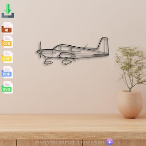 May include: A black metal airplane wall art piece. The airplane has a propeller, wings, and a tail. The art is mounted on a light beige wall above a wooden table. A small plant in a beige pot is on the table.