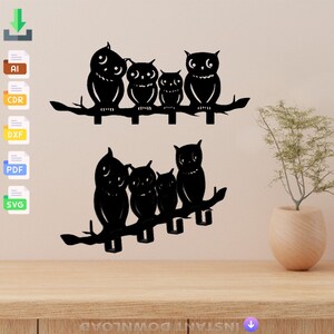 May include: Black metal owl silhouette wall hooks. Five owls are perched on a branch, with the largest owl in the center. The owls are all facing forward, with their wings spread out. The hooks are designed to hold keys, coats, or other items.