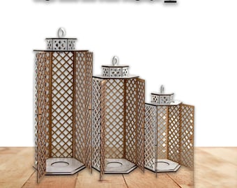 May include: Three wooden candle lanterns of different sizes with a geometric lattice design. The lanterns are made of wood and have a white finish. They are arranged in a row from largest to smallest.