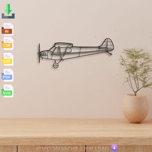 Peut inclure: Une décoration murale en métal noir représentant un avion. L'avion comprend une hélice, des ailes et une queue, et est monté sur un mur de couleur claire. L'œuvre d'art est un objet décoratif pour les passionnés d'aviation.