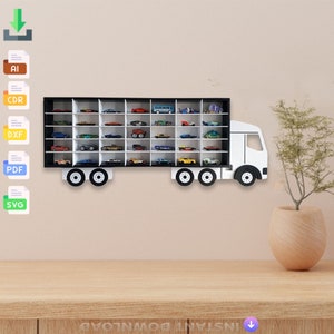 Könnte beinhalten: Ein weißes und schwarzes Spielzeug-LKW-Regal mit 36 Fächern zum Ausstellen von Spielzeugautos. Das Regal ist in Form eines Sattelzuges mit einer weißen Kabine und einem schwarzen Anhänger gestaltet. Das Regal ist an einer Wand montiert.