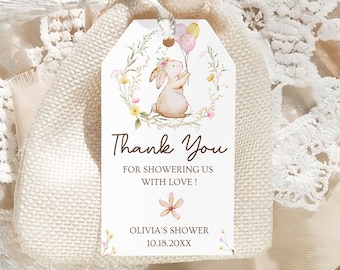 May include: A white burlap bag with a brown tassel and a thank you tag. The tag features a watercolor illustration of a bunny holding balloons with a floral wreath around it. The text on the tag reads "Thank You for showering us with love! Olivia's Shower 10.18.20XX".