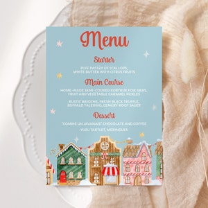 Peut inclure: Une carte de menu bleue et blanche avec une illustration de village d'hiver festif. Le menu propose une entrée, un plat principal et un dessert. Le texte indique : "Menu, Entrée, Pâté feuilleté de Saint-Jacques, Beurre blanc aux agrumes, Plat principal, Foie gras de Kortrijk mi-cuit fait maison, Pickles de fruits et légumes au caramel, Brioche rustique, Truffe noire fraîche, Taleggio de buffle, Sauce à la racine de céleri, Dessert, "Comme un Javanai" Chocolat et café, Tartelette au yuzu, Meringues."