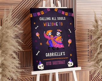 May include: A Día de los Muertos-themed sign on an easel. The dark purple sign features dancing skeleton figures, maracas, and the text "Calling All Souls Welcome to Gabriella's 8th Birthday."
